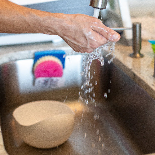 person holds hand under running water